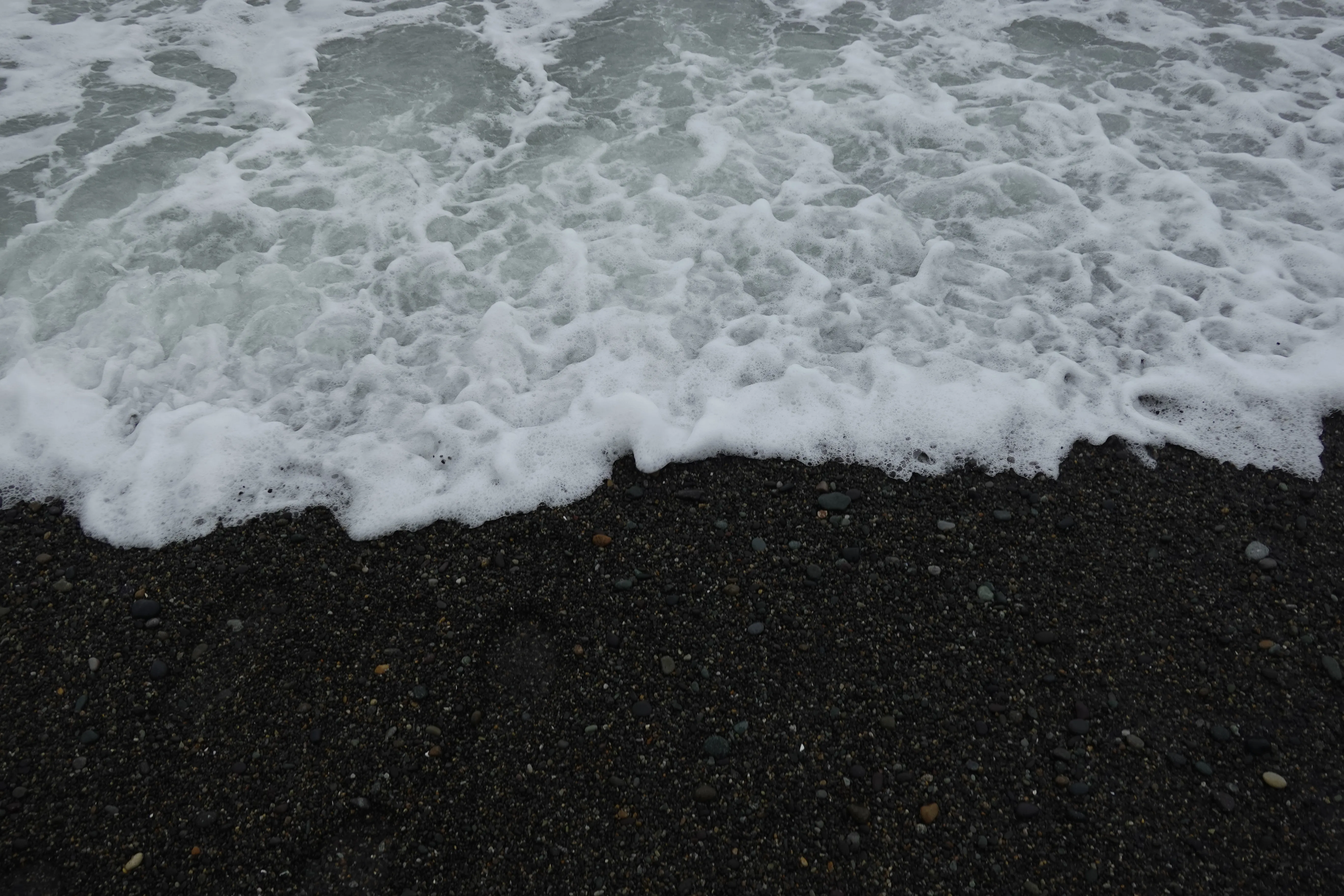 Close up shot of wave breaking on the shore of Lima beach